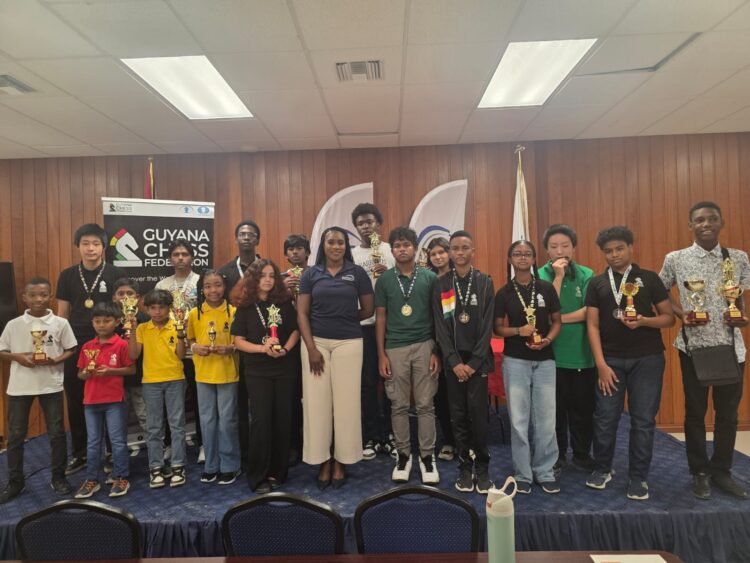 Prize Winners for the Junior Chess Championship Qualifiers posed with Ms. Yulanda Armstrong from EnerMech Guyana