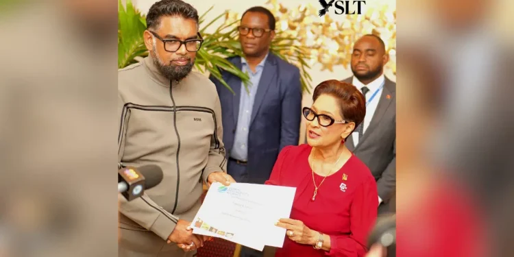 President Dr Mohamed Irfaan Ali hands over a Global Biodiversity Alliance membership certificate to Trinidad and Tobago’s Prime Minister Kamla Persad-Bissessar