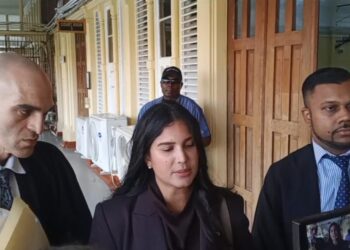Attorneys Siand Dhurjon and Damien DaSilva with Hana Mohamed outside of the court room. (Kaieteur News photo)