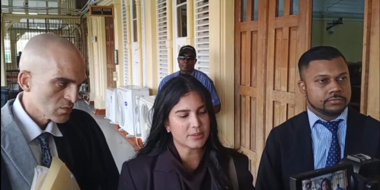 Attorneys Siand Dhurjon and Damien DaSilva with Hana Mohamed outside of the court room. (Kaieteur News photo)