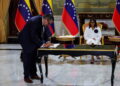 FILE PHOTO: Venezuela's interim President Delcy Rodriguez looks on as Mariano Vela, President of Chevron in Venezuela signs an oil agreement between Chevron and Venezuela's state oil company PDVSA, in Caracas, Venezuela April 13, 2026. REUTERS/Leonardo Fernandez Viloria/File Photo