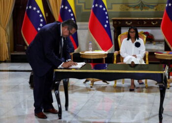 FILE PHOTO: Venezuela's interim President Delcy Rodriguez looks on as Mariano Vela, President of Chevron in Venezuela signs an oil agreement between Chevron and Venezuela's state oil company PDVSA, in Caracas, Venezuela April 13, 2026. REUTERS/Leonardo Fernandez Viloria/File Photo
