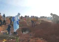 A health worker sprays disinfectant in a freshly dug grave for the body of Jacques Lobo Dhena, who died of Ebola, in Bunia, Ituri province, eastern Congo, Wednesday, Aug. 12, 2026. (AP Photo/Dieudonne Dirole)