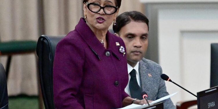 fighting against crime: Prime Minister Kamla Persad-Bissessar delivers a statement during yesterday’s sitting of Parliament. At right is Public Utilities Minister Barry Padarath. —Photo: JERMAINE CRUICKSHANK