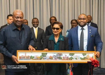 A GIFT: Prime Minister Kamla Persad-Bissessar, centre, and Foreign Affairs Minister Sean Sobers, right, present a painting of the Magnificent Seven to John Dramani Mahama, President of the Republic of Ghana, before their bilateral meeting in New York, yesterday.