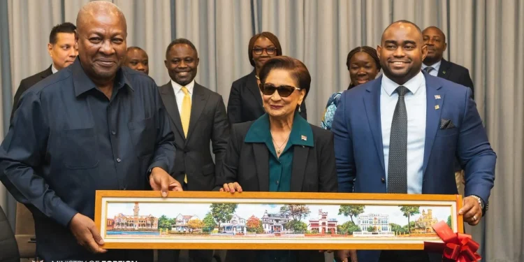 A GIFT: Prime Minister Kamla Persad-Bissessar, centre, and Foreign Affairs Minister Sean Sobers, right, present a painting of the Magnificent Seven to John Dramani Mahama, President of the Republic of Ghana, before their bilateral meeting in New York, yesterday.