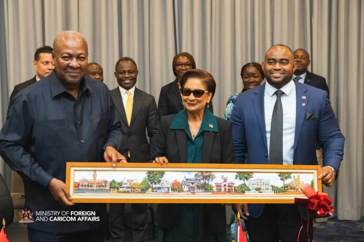 A GIFT: Prime Minister Kamla Persad-Bissessar, centre, and Foreign Affairs Minister Sean Sobers, right, present a painting of the Magnificent Seven to John Dramani Mahama, President of the Republic of Ghana, before their bilateral meeting in New York, yesterday.