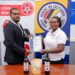 GNBS Head of Certification Services (ag), Keon Rankin, handing over the certificate to Managing Director of Sand Flower Products, Xuxa Lowe