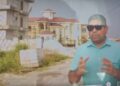 Opposition Leader Azruddin Mohamed standing in front of Mustapha's property