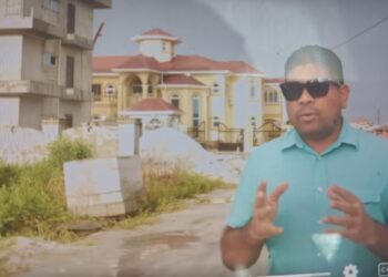 Opposition Leader Azruddin Mohamed standing in front of Mustapha's property