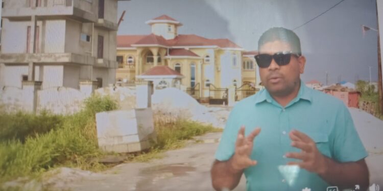 Opposition Leader Azruddin Mohamed standing in front of Mustapha's property