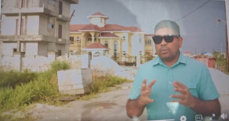 Opposition Leader Azruddin Mohamed standing in front of Mustapha's property