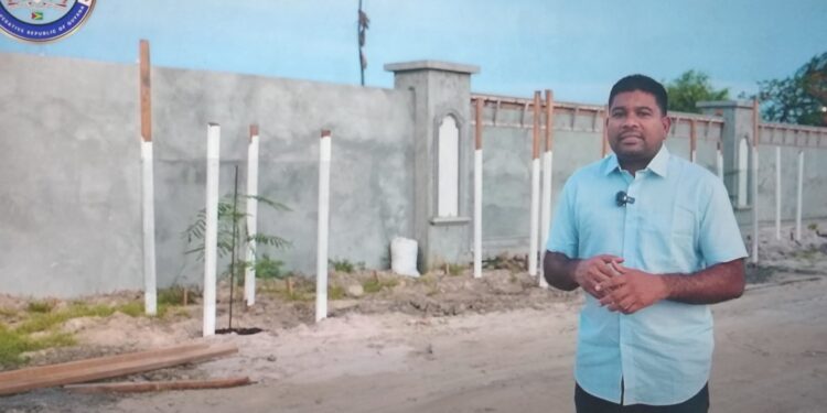 Opposition Leader Azruddin Mohamed standing in front of the wall at Leonora, West Coast Demerara (screen grab photo)
