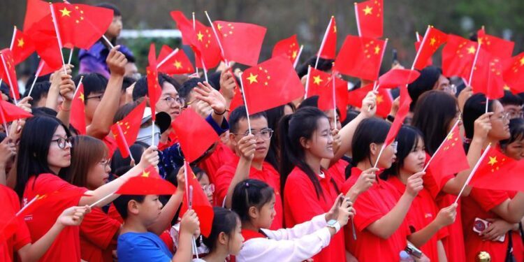 People watch a performance after attending a flag-raising ceremony at Dongfeng Square in Kunming, southwest China's Yunnan Province, Oct. 1, 2026. (Photo by Zheng Yi/Xinhua)