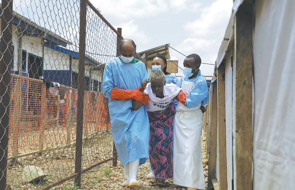 Healthcare workers assist a patient who has been cleared of Ebola at a treatment center in Beni, North Kivu Province, Democratic Republic of the Congo, on Tuesday. SEBASTIEN KITSA MUSAYI/AP