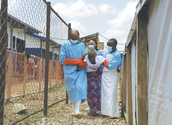 Healthcare workers assist a patient who has been cleared of Ebola at a treatment center in Beni, North Kivu Province, Democratic Republic of the Congo, on Tuesday. SEBASTIEN KITSA MUSAYI/AP