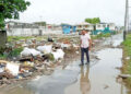 then PPP Minister of Local Government Nigel Dharamlall walks by 'inspects' garbage in the city (Guyana Chronicle) photo)