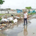 then PPP Minister of Local Government Nigel Dharamlall walks by 'inspects' garbage in the city (Guyana Chronicle) photo)
