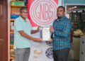 GNBS Head of Certification Services (ag), Keon Rankin, handing over the certificate to Deputy Factory Manager at Gafsons Industries, Jitendra Mishrah