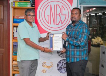 GNBS Head of Certification Services (ag), Keon Rankin, handing over the certificate to Deputy Factory Manager at Gafsons Industries, Jitendra Mishrah