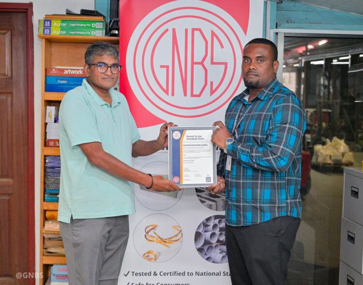 GNBS Head of Certification Services (ag), Keon Rankin, handing over the certificate to Deputy Factory Manager at Gafsons Industries, Jitendra Mishrah