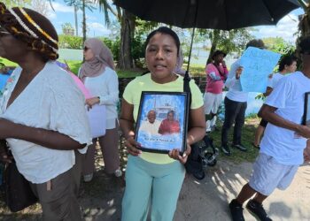 MV Barima protest-   Centre - Jasmine holding photos of Neil and Henry Cort who perished in the July 18, 2026 sinking