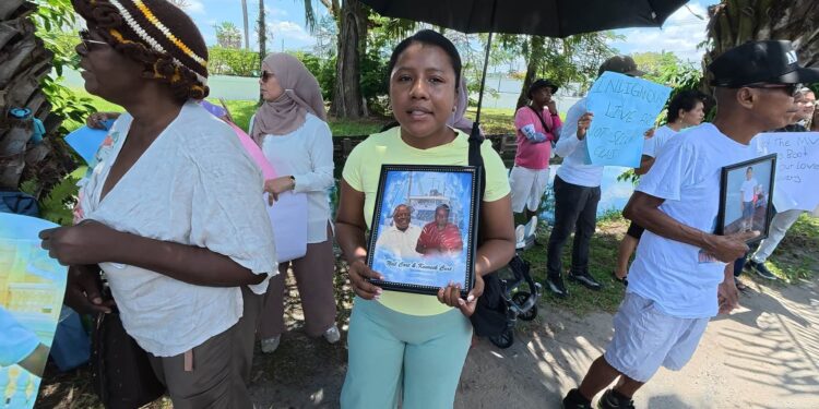 MV Barima protest-   Centre - Jasmine holding photos of Neil and Henry Cort who perished in the July 18, 2026 sinking
